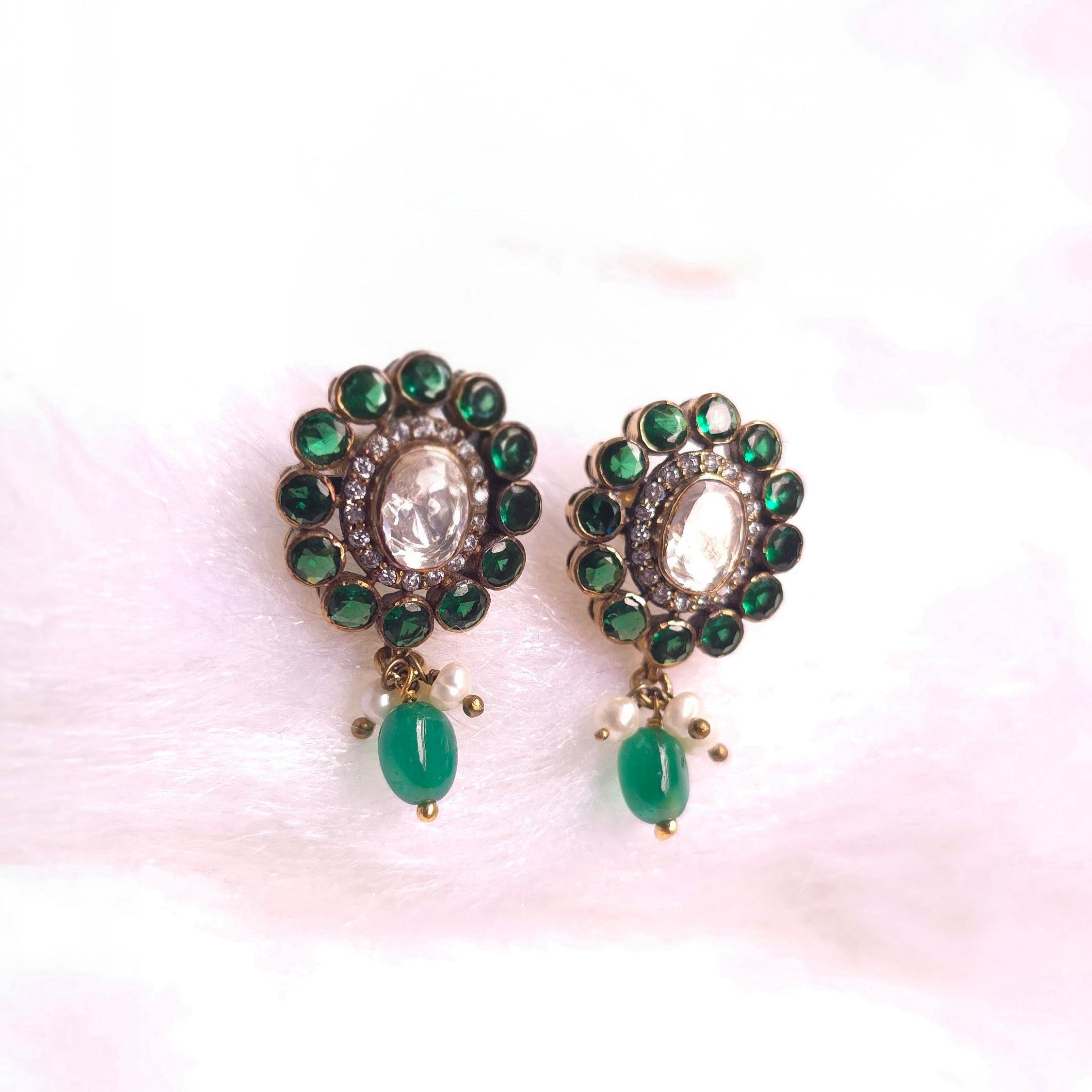 Emerald Charm Studs featuring radiant green emeralds and a delicate design for elegance and style.