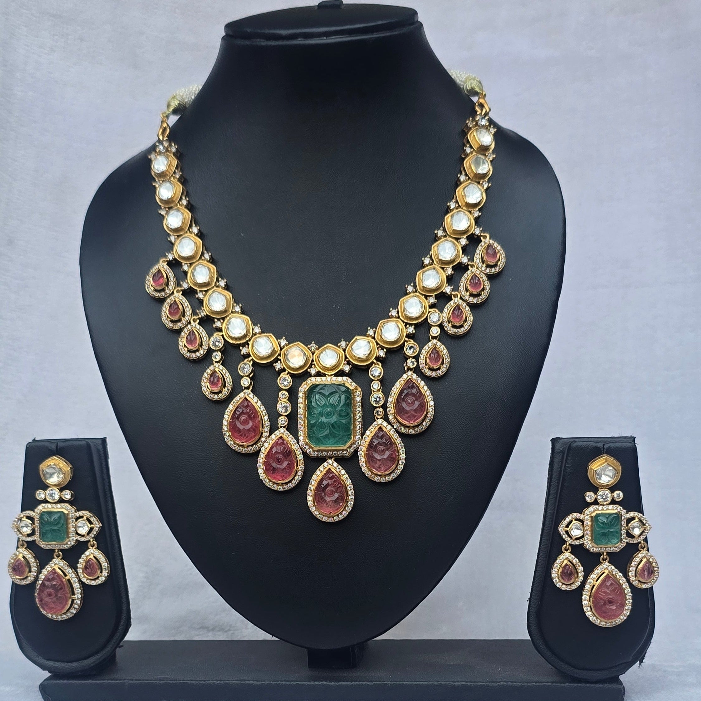 Polki Ruby Pink Tourmaline Necklace with intricate design and matching earrings on display.